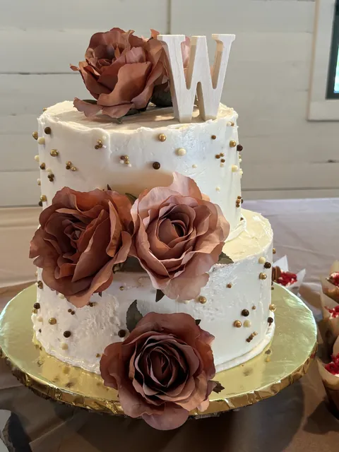 A two tier wedding cake dressed with dusty roses