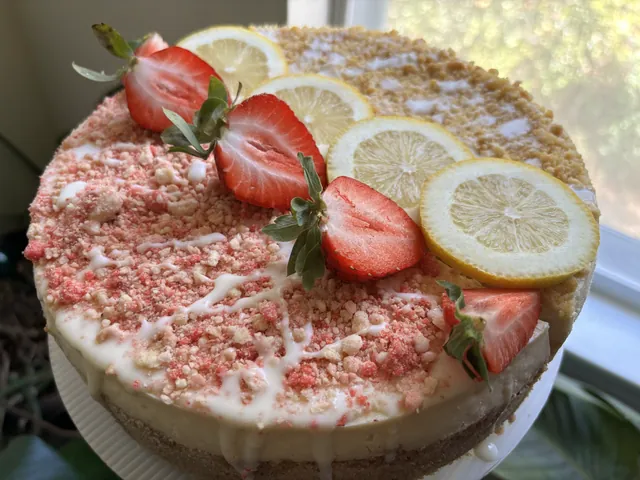 A whole strawberry lemon cheesecake with strawberry crumb