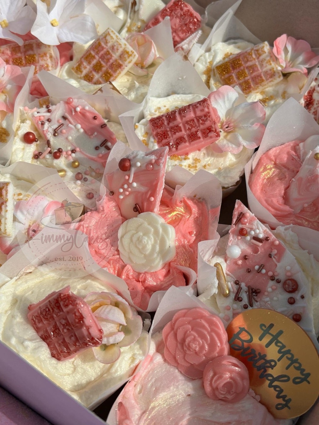 Cupcakes piped in soft pink with sugar roses